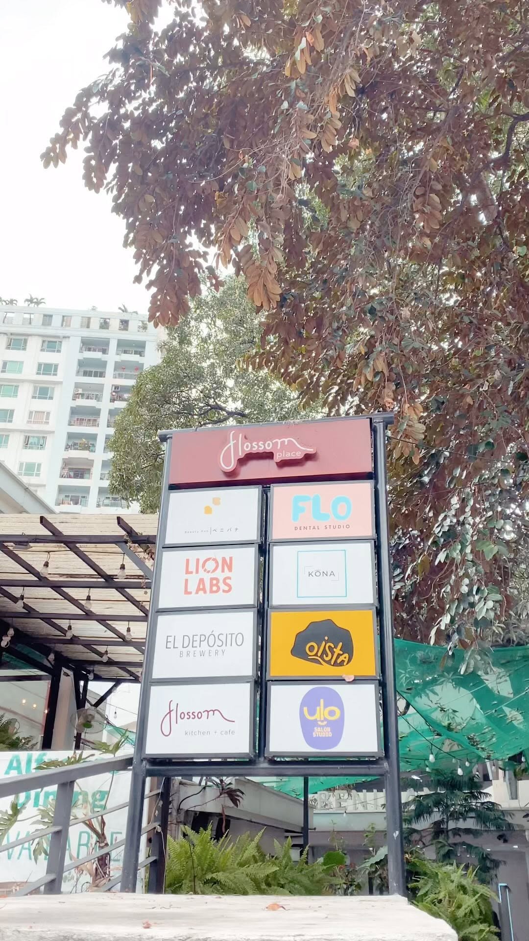 Flossom Place entrance directory sign with lush garden backdrop